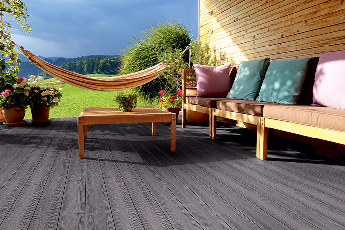 Gray WPC terrace with wooden furniture, hammock and far view