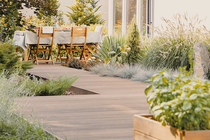 Large terrace with garden furniture, bordered with plants